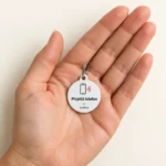 Zawieszka NFC PupiLink na otwartej dłoni, pokazuje rozmiar